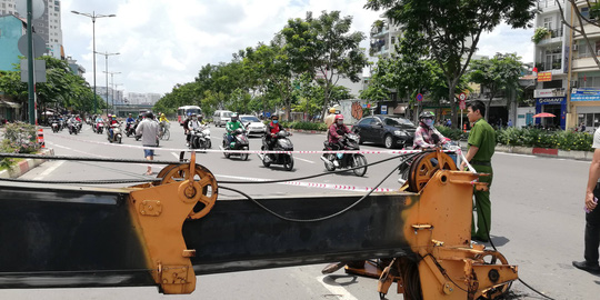 Cần cẩu mất cân bằng đổ sập chắn ngang đường ở Phạm Văn Đồng