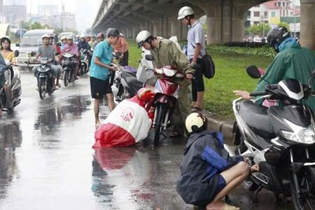 Dừng xe trên đường để mặc áo mưa có vi phạm luật giao thông không?