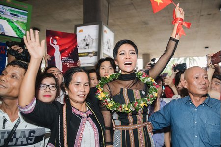 H'Hen Niê bật khóc, tay cầm bánh mì giơ cao trong ngày trở về