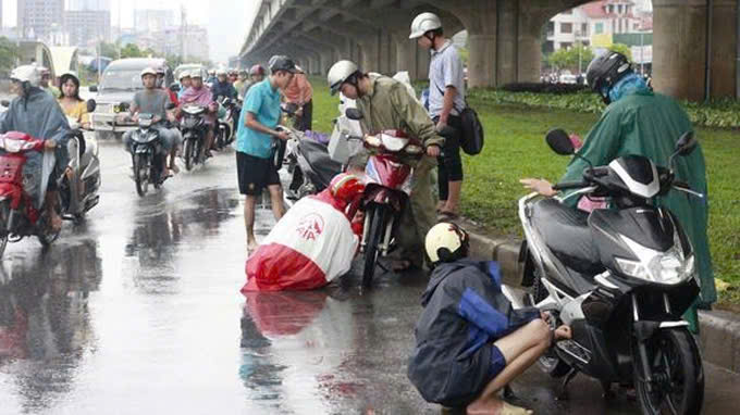 Dừng xe trên đường để mặc áo mưa có vi phạm luật giao thông không?