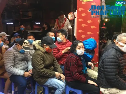 Người dân đeo khẩu trang xếp hàng chờ đến lượt mua vàng ngày vía Thần Tài